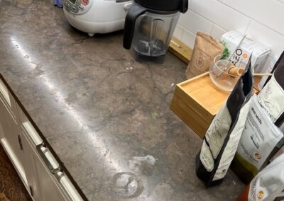 A kitchen counter with a blender and utensils on it.